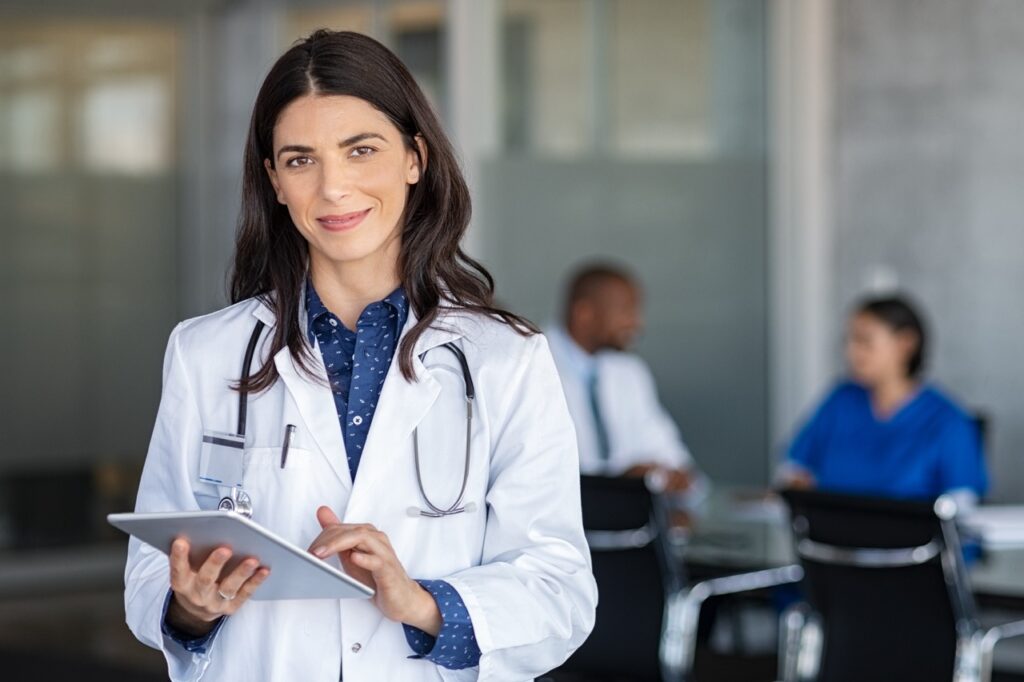 Doctor holding digital tablet at meeting room