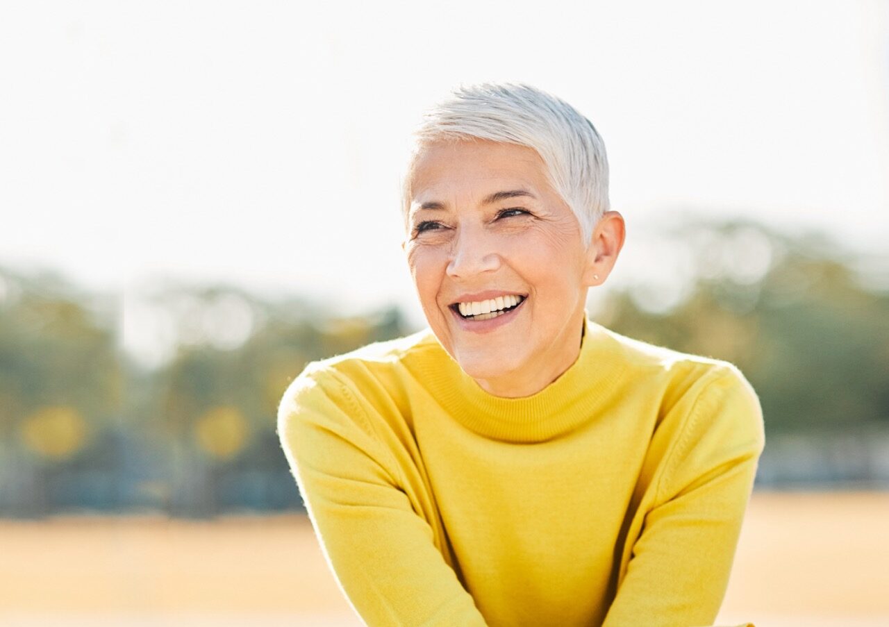 Portrait of an elderly woman outdoors. Happy senior woman in park