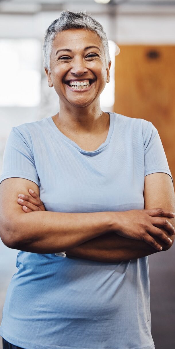 Senior black woman, gym and smile portrait of a person happy about fitness and exercise. Sports, happy and pilates fitness studio of mature female with arms crossed proud about wellness and health.