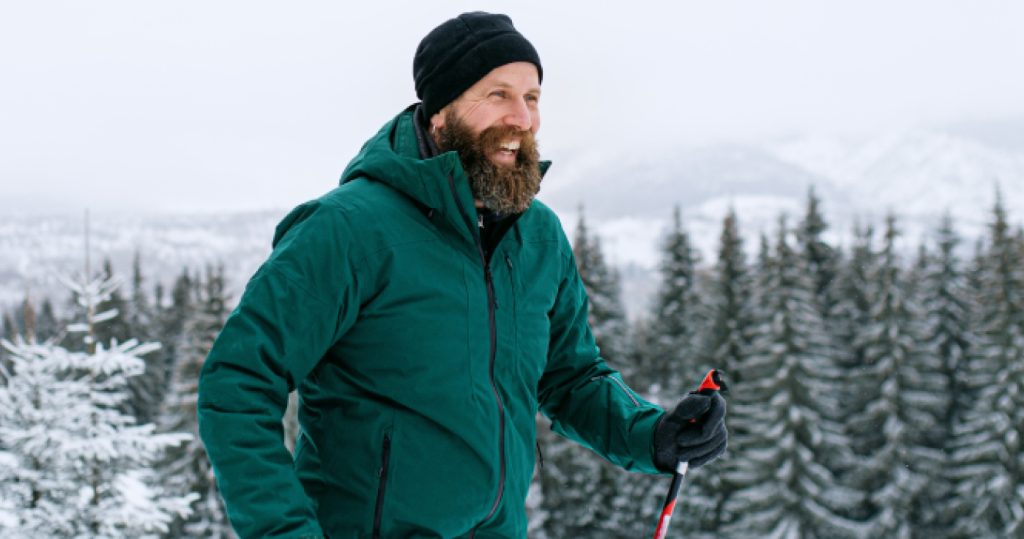 man with beard cross country skiing in the mountains