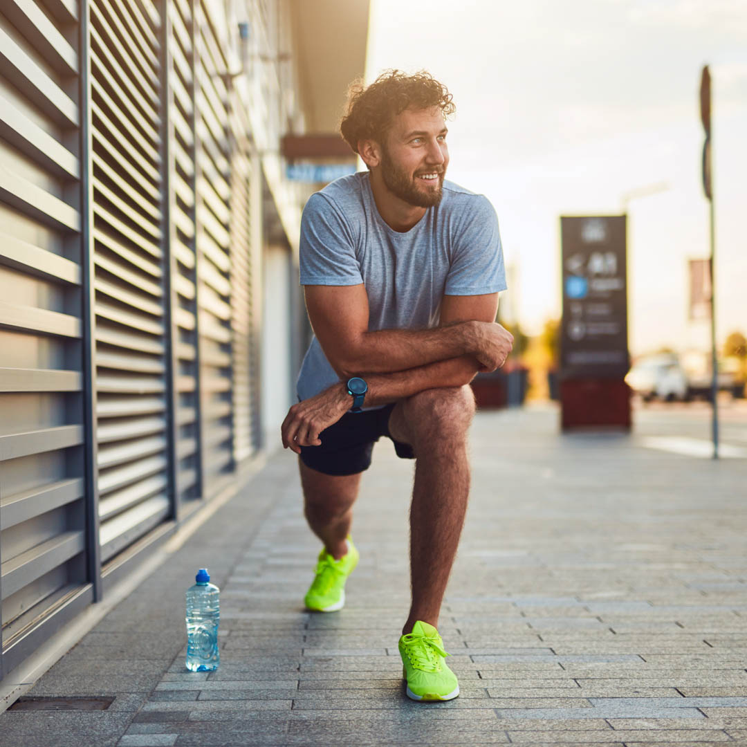 Young man exercising / stretching in urban area.
