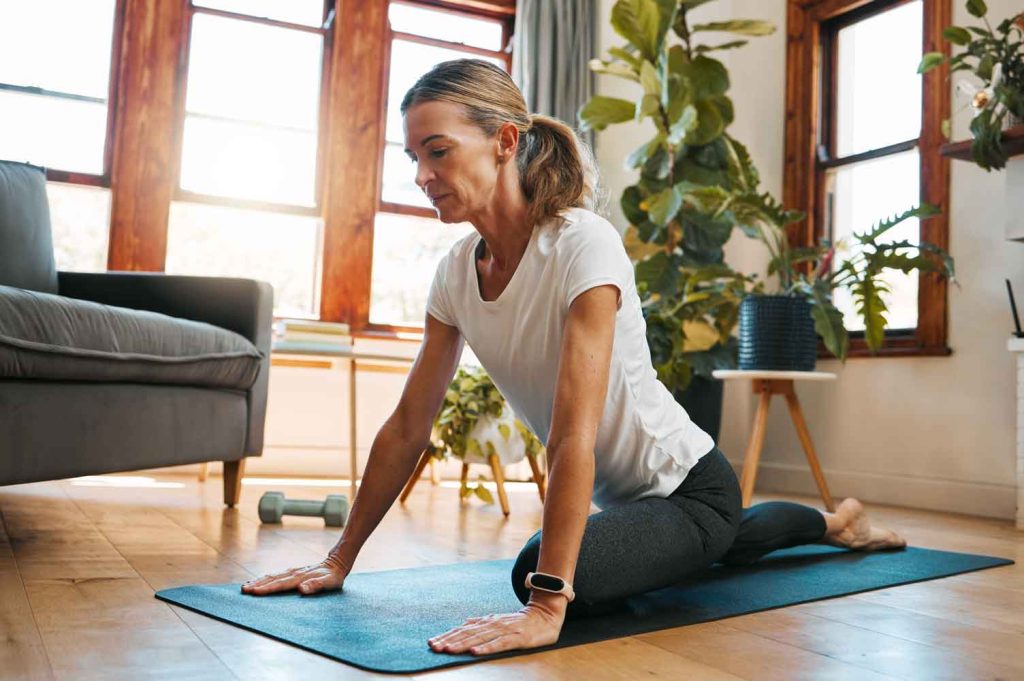 Mature woman at home in yoga pose