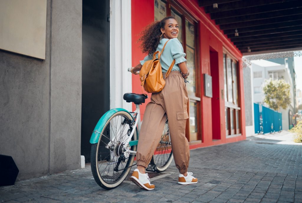 Girl walking bike on the sidewalk